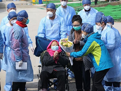 A recovered patient (C in wheelchair), 98, is discharged from Leishenshan Hospital, the makeshift hospital for the COVID-19 coronavirus patients, in Wuhan in China's central Hubei province on March 1, 2020.