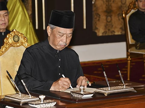 Malaysia's incoming Prime Minister Muhyiddin Yassin signs his appointment document after the oath in front of King Sultan Abdullah Sultan Ahmad Shah during his swearing-in ceremony as the country's new leader at the National Palace in Kuala Lumpur.