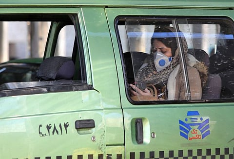 An Iranian woman wearing a protective mask is pictured in the back seat of a taxi in Tehran on March 2, following the COVID-19 illness outbreak, which Iran says has claimed 66 lives out of 1,501 cases of infection in the Islamic republic since February. The novel coronavirus has sparked intense debate in Iran between ultra-conservative Shiite clerics and the government on how to most effectively tackle the deadliest outbreak of the disease outside China.