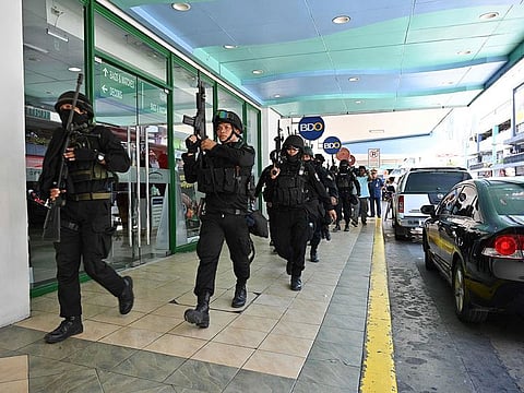 Members of a police SWAT team take positions outside one of the entrances to a mall after a hostage situation was reported in suburban Manila on March 2, 2020.