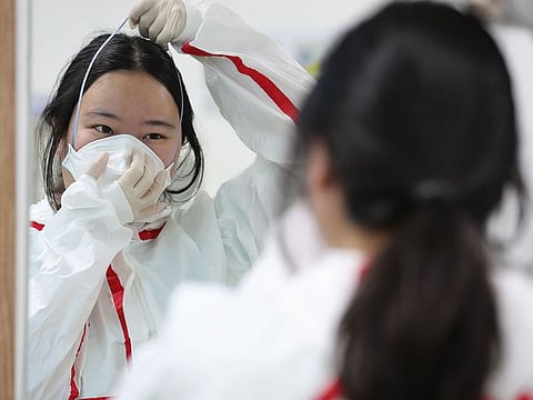 Medical staff members wear protective gear to care patients infected with the COVID-19 coronavirus at a hospital in Daegu on March 2, 2020. South Korea reported nearly 500 new coronavirus cases on March 2, sending the largest national total in the world outside China past 4,000.
