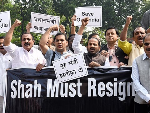Leader of Congress in Lok Sabha Adhir Ranjan Chowdhury along with party MPs hold placards and shout slogans demanding resignation of Union Home Minister Amit Shah during a protest against the Delhi Riots, during the Budget Session of Parliament in New Delhi on Monday.
