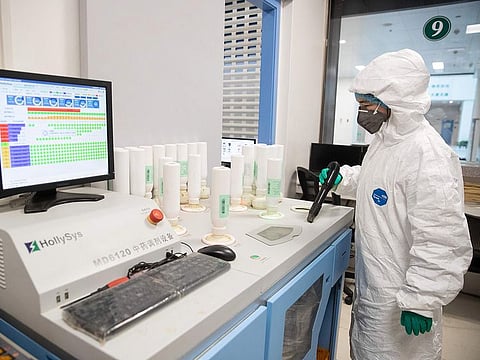A medical worker produces traditional Chinese medicine to treat patients infected by the COVID-19 coronavirus at a hospital in Wuhan in China's central Hubei province on March 2, 2020.