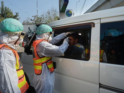 A Pakistani rescue personnel checks the body temperature of a man during a drill exercise as a preventive measure for the spread of the of COVID-19 coronavirus, in Peshawar on March 1.