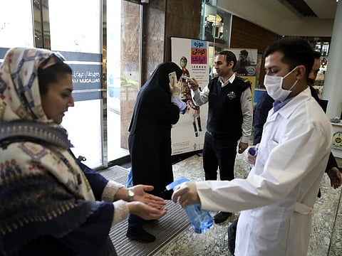 People have their temperature checked and their hands disinfected as they enter the Palladium Shopping Centre, in northern Tehran, Iran, Tuesday.