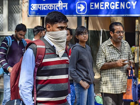 A man uses a handkerchief to cover his face in the wake of the coronavirus outbreak at RML Hospital in New Delhi on Tuesday. India on Monday reported two new cases of the virus, including one from the national capital.