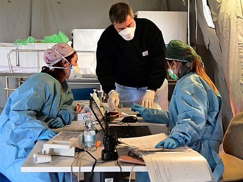 Medical personnel work in the pre-triage medical tent located in front of the Cremona hospital, in Cremona, northern Italy, on Wednesday. Italy will recommend people stop kissing in public, avoid shaking hands and keep a safe distance from each other to limit the spread of the novel coronavirus.