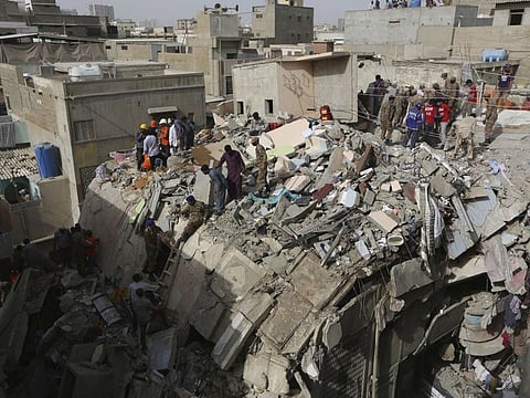 Pakistani volunteers look for survivors amid the rubble of a collapsed building in Karachi, Pakistan, Thursday, March 5, 2020. A couple of people were killed and several were injured when the five-story building collapsed in a congested area of Karachi, an official said. (AP Photo/Fareed Khan)