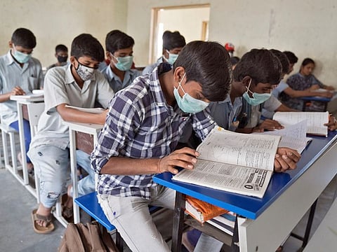 Students wearing protective masks attend a class in a government-run school in Hyderabad on Thursday.