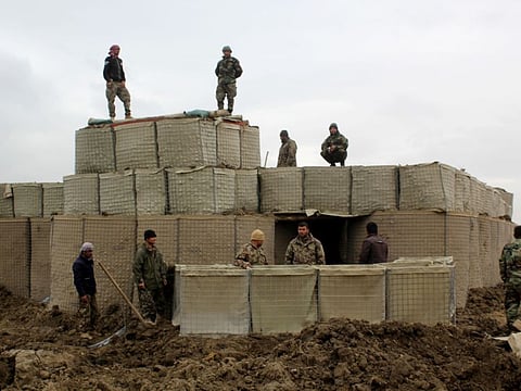 Afghan security forces stand guard at an Afghan National Army (ANA) outpost after an attack by Taliban militants, in Kunduz Province on Wednesday. The US launched an airstrike against Taliban fighters to defend Afghan forces on March 4.