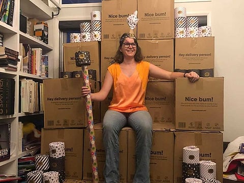 A woman sits on top of a "throne" made of boxes containing toilet paper in Toowoomba, Australia March 5, 2020. in this picture obtained from social media.