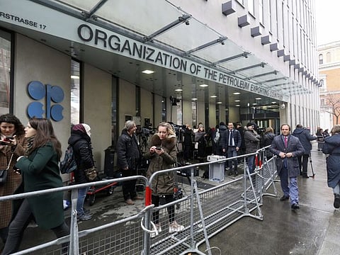 People stand in front of the headquarters of the Organization of the Petroleum Exporting Countries, OPEC, in Vienna, Austria, Friday, March 6, 2020.