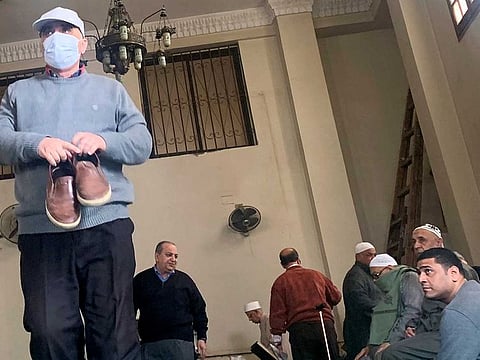 People look at a man wearing a protective mask as a means of prevention against the coronavirus disease (COVID-19) at the Al Rahman mosque, after Friday prayers, in the southern suburb of Maadi, on the outskirts of Cairo, Egypt March 6, 2020.