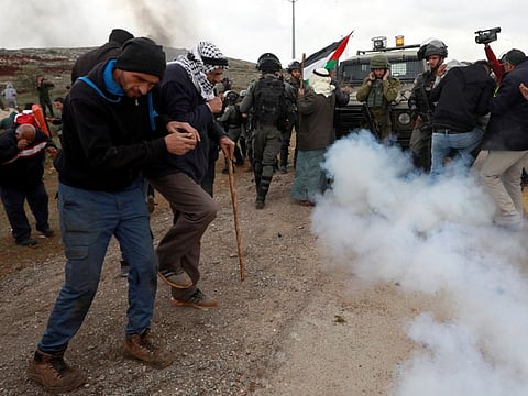 Palestinian demonstrators react to a sound grenade thrown by Israeli forces during a protest against Jewish colonies in the village of Qusra, in the Israeli occupied West Bank, March 2, 2020.