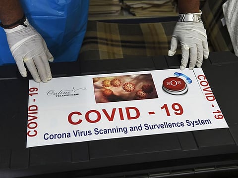 Team member of Ragesh Shah, a scientist and founder of Online Telemedicine Research Institute, puts a sticker on a kit prepared for the coronavirus scanning and surveillance system, in Ahmedabad on March 6.