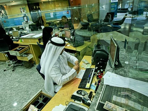 Teller at at a Bank in Dubai. Analysts expect impact of coronavirus on non-oil private sector could further slowdown privates sector loan demand in the UAE.