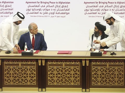 US peace envoy Zalmay Khalilzad, left, and Mullah Abdul Gani Baradar, the Taliban's top political leader, sign a peace agreement in Doha on February 29.