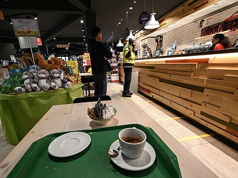 A wiress (right) takes a customer's order in a deserted cafeteria restaurant and shop at a gas station and service area of the E70 - A21 highway in Stradella, south of Pavia, south-western Lombardy, in one of Italy's quarantine red zones on March 9.