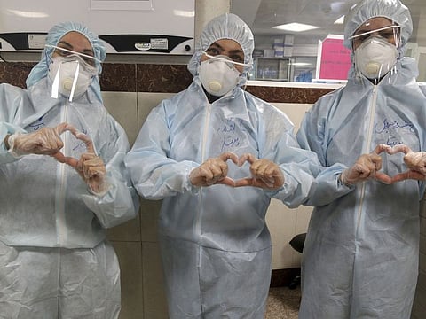 Nurses make a sign of heart with their fingers, in a ward dedicated for people infected with the new coronavirus, at a hospital in Tehran.