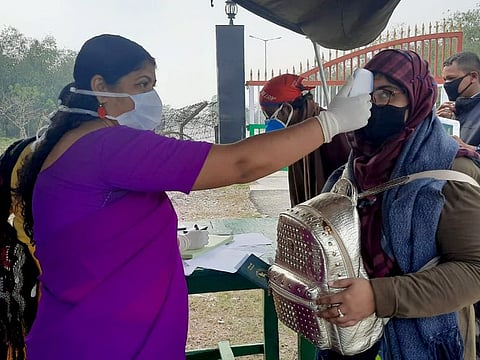 Government health officials use a thermal screening device on Bangladeshis entering into India to detect symptoms of Covid-19, at a temporary medical camp in Fulbari, Indo-Bangladesh Border on Monday.
