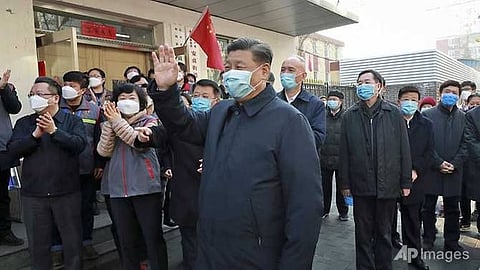 Chinese President Xi Jinping (centre) wearing a protective face mask waves as he inspects the novel coronavirus pneumonia prevention and control work at a neighbourhoods in Beijing.