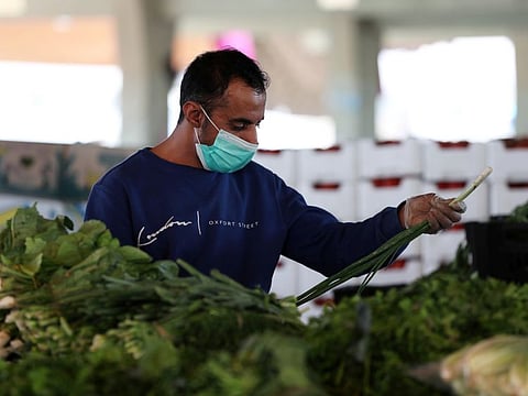 A man wearing a protective face mask sells vegetables at a market, after Saudi Arabia imposed a temporary lockdown on the province of Qatif following the spread of coronavirus, in Qatif on March 9.
