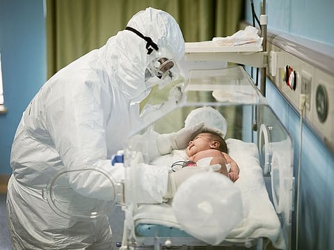 A medical staff attends to a baby with novel coronavirus at the Wuhan Children’s Hospital, in Wuhan.