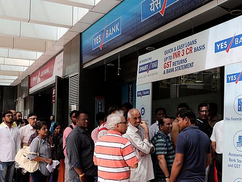 Depositors stand in queue for withdrawals outside Yes bank in Mumbai, India, Friday, March 6, 2020. Panicked depositors rushed to branches of a cash strapped private Yes Bank to withdraw money as the central bank placed it under a moratorium and superseded its board and it capped deposit withdrawals at rupees 50,000 (USD$ 705) per account for a month
