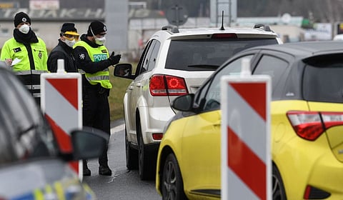 Czech special police officers, with a protective mask, check the temperature of a driver during sanitary checks at the border crossing between Germany and Czech Republic, near the German village of Furth and the Czech village Nova Kubice in a measure to protect against the spread of the novel coronavirus, on March 9, 2020.