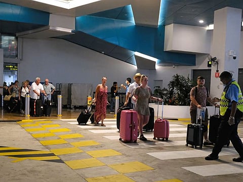 Passengers of the Costa Fortuna cruise ship are seen with their luggages outside the arrival hall of the Marina Bay Cruise Center Singapore on Tuesday, March 10, 2020. The cruise ship barred from Thailand and Malaysia due to coronavirus fears has returned to Singapore a week after it set sail from the city-state.