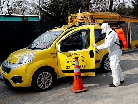 A municipality worker wearing a protective suit sanitises a taxi in Karaagac district against the coronavirus disease near Turkey's Pazarkule border crossing with Greece's Kastanies, in Edirne, Turkey on March 10.