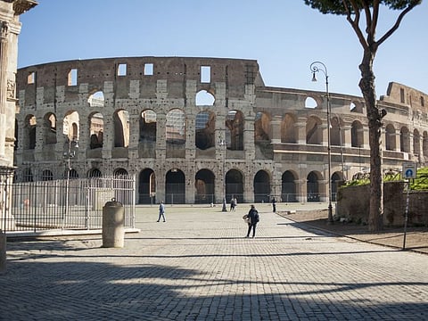 A few pedestrians walk near the Colosseum in Rome, Italy, on Wednesday. Italian Prime Minister Giuseppe Conte’s government is ready to spend as much as 25 billion euros ($28.3 billion) on stimulus measures to shield the economy from Europe's worst outbreak of the coronavirus.