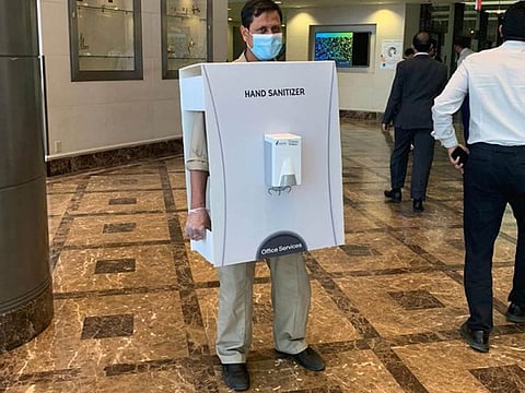 An image went viral online showThe image of the Asian worker carrying a large sanitiser dispenser triggered accusations of racism.
