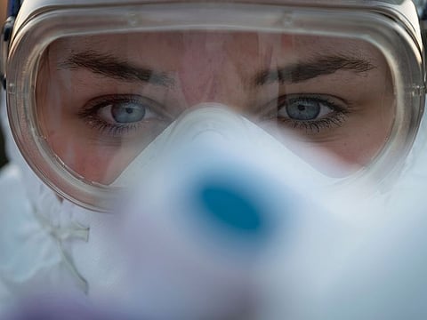A medical worker wears protective goggles as she prepares to measure motorists' body temperatures at the Slovenian-Italian border crossing near Nova Gorica, on March 11, 2020, after Slovenia's government announced it would close its border with Italy, hard hit by the outbreak of COVID-19, the new coronavirus.