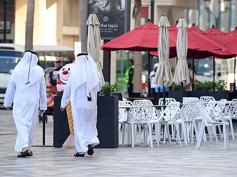 Image used for illustrative purposes only: Emirati men walk along the empty beachside boulevard of Jumeirah Beach Residence on March 12