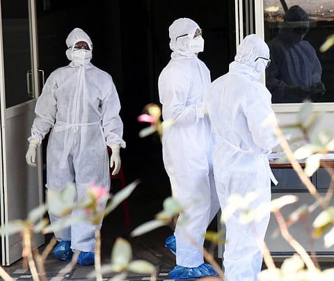 Workers wearing protective suits outside the Special Isolation Ward of Coronavirus patients at Aluva government general hospital in Kochi on Thursday.
