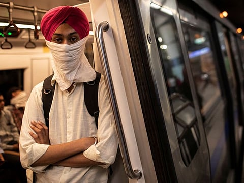 A commuter wears a handkerchief as a mask as he travels on a metro train, amid coronavirus disease (COVID-19) fears, in New Delhi, on March 13, 2020.