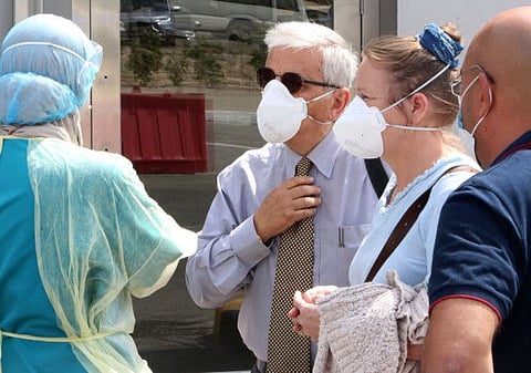 Kuwait health ministry workers prepare to scan expatriates living in Kuwait who returned from Egypt, Syria and Lebanon, as they arrive to be tested for coronavirus in Kuwait City on March 12.