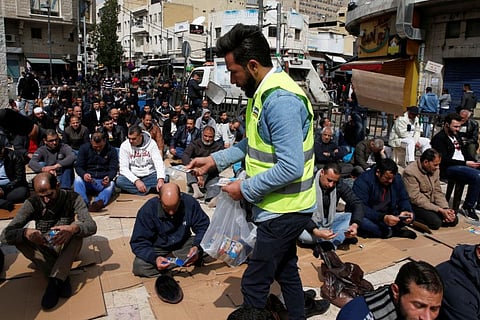 A staff member from sanitizing company distributes hand sanitiser for free for worshippers during Friday prayers outside al Husseini mosque in downtown Amman on March 6.