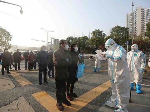 Medical workers check patients who recovered from coronavirus as they arrive to be tested again at a hospital in Wuhan, in China's central Hubei province on March 14.