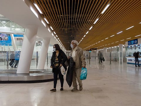 Travelers wear protective masks while walking through Miguel Hidalgo y Costilla International Airport in Guadalajara, Mexico, on Friday, Feb. 28, 2020. The World Health Organization raised its global risk assessment for the new coronavirus to "very high" from "high" as some countries struggle to contain the pathogen. Photographer: Cesar Rodriguez/Bloomberg