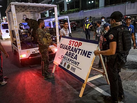 Members of a quarantine team set up a checkpoint area in Cainta City, Manila, Philippines.