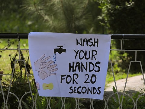 A sign is put up near a stall during an awareness compaign by an NGO for a preventive measure against the coronavirus, at the St John Cathedral premises in Peshawar on March 15.