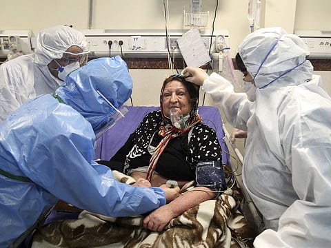 Medics treat a patient infected with the new coronavirus, at a hospital in Tehran. Iran's healthcare system is being overwhelmed by the scale of the outbreak in the country.