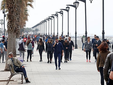 People walk along Beirut's seaside Corniche, Lebanon March 15, 2020.