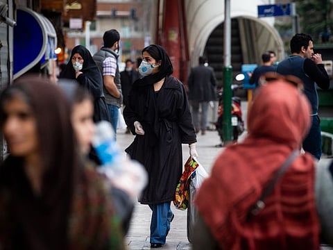 Pedestrians wear protective masks and surgical gloves while walking in central Tehran, Iran, on Sunday, March 15, 2020. Iran’s President Hassan Rouhani announced a series of banking, welfare and tax relief measures to support business and families as the coronavirus outbreak puts severe strain on the economy. Photographer: Ali Mohammadi/Bloomberg
