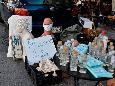 Masks marked "1 Euro each"  and antiseptics are displayed for sale at a flea market in Athens on March 15, 2020.