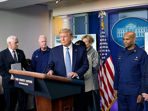 President Donald Trump is trailed by Vice President Mike Pence as he arrives to speak to reporters at the White House about the coronavirus pandemic on Monday, March 16, 2020.