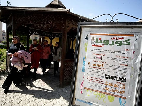 Students walks past information and instructions on coronavirus disease at Cairo University in Egypt.