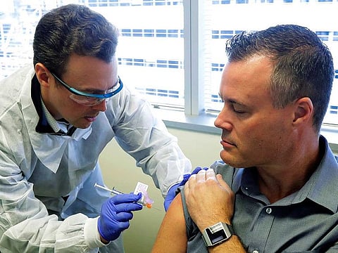 Pharmacist Michael Witte gives Neal Browning a shot in the first-stage safety study clinical trial of a potential vaccine for the COVID-19 coronavirus at the Kaiser Permanente Washington Health Research Institute in Seattle on March 16, 2020.
